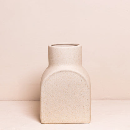 Kleine, rechthoekige vaas met afgeronde hoeken, minimalistisch uitgevoerd in een neutrale zandkleur met een subtiele ribbelstructuur.